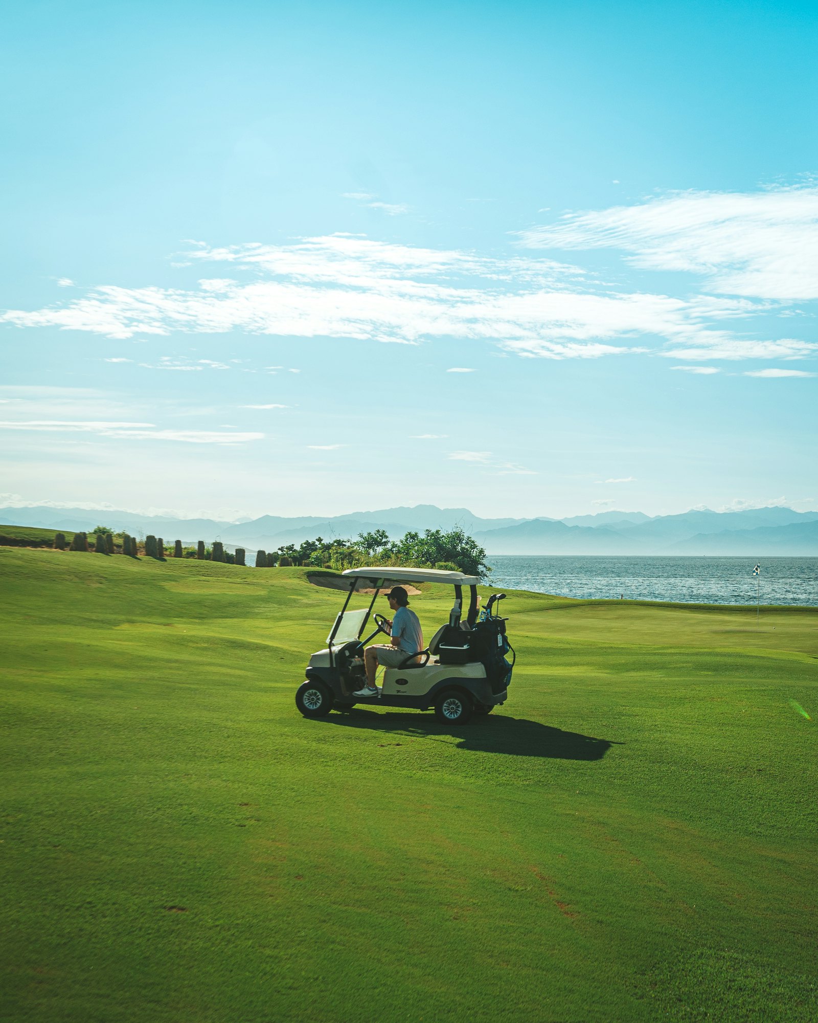 A golf cart driving along a seaside fairway